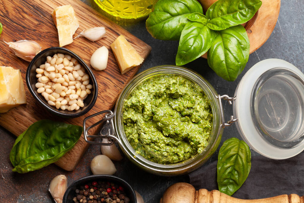 Homemade pesto sauce with basil leaves, pine nuts, parmesan and garlic. Top view flat lay - Fotografie, Obrázek