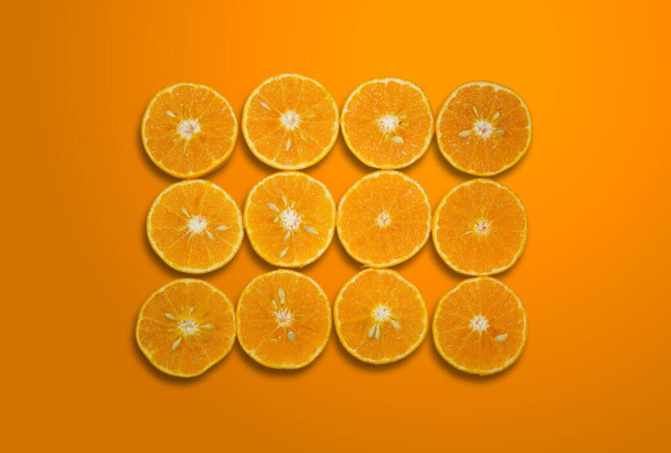 Draufsicht Sommermuster frischer Orangenscheiben isoliert auf orangefarbenem Farbverlauf Hintergrund mit Clipping Path.Orangen halb aufgeschnittenem Muster. Hintergrund der Hälfte geschnittene Orangen auf orangefarbenem Hintergrund. - Foto, Bild