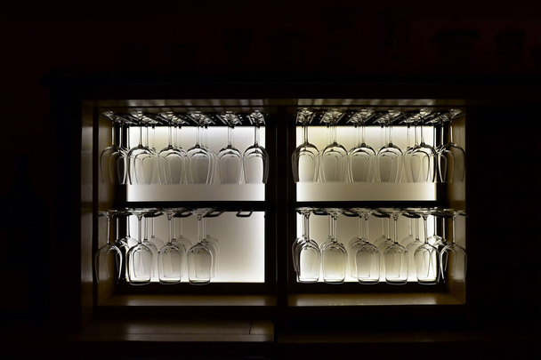 Bicchieri da vino capovolti nell'armadio con retroilluminazione - Foto, immagini