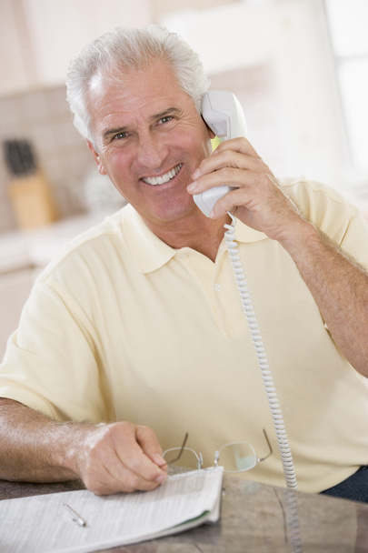 Man in kitchen on telephone smiling - Фото, зображення
