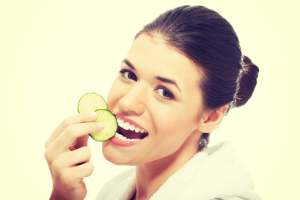Beautiful woman holding slices of cucumber - Photo, image