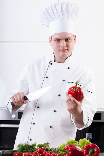 Young chef with veggies and knife - Foto, afbeelding