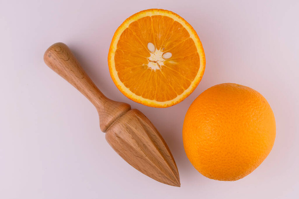 Narancs és fa gyümölcsfacsaró fehér háttérrel. Lapos fektetés. - Fotó, kép