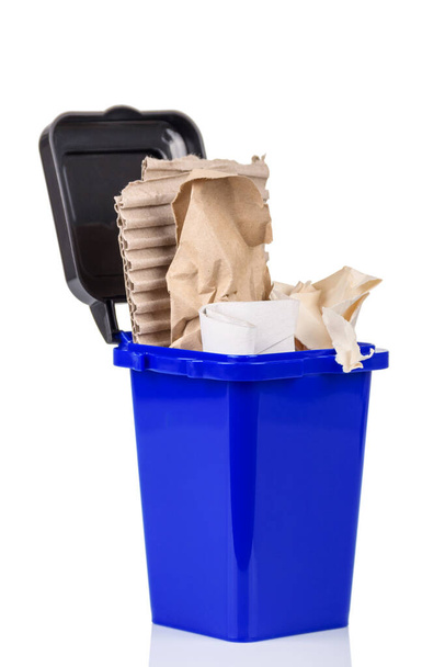 Household waste sorting concept. Blue trash bin with paper trash isolated on white background - Photo, image