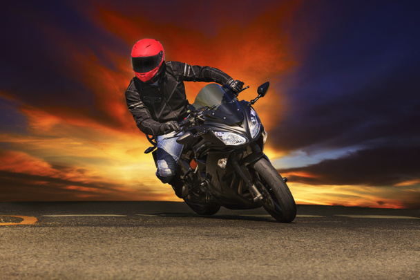 young man riding big bike motorcycle on asphalt roads against be - Photo, Image