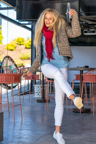 Великолепная блондинка позирует на улице в осенней одежде - Фото, изображение