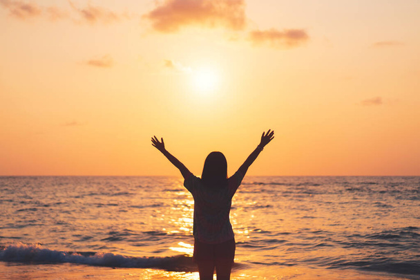 Kopierraum von Frau erheben sich Hand in Hand am Sonnenuntergang Himmel am Strand und Insel Hintergrund. Freiheit und Reiseabenteuer. Vintage Ton Filtereffekt Farbstil. - Foto, Bild