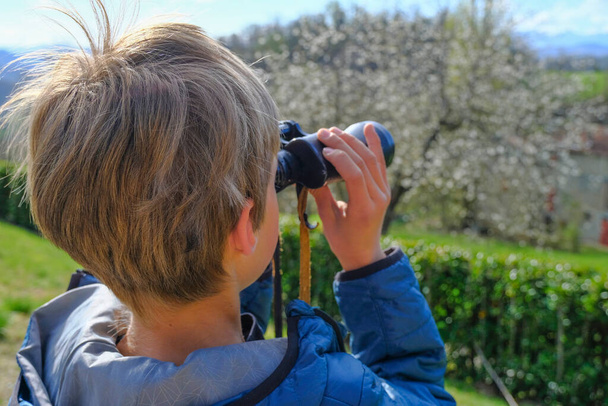 Rapaz a observar a vista com binocular. Mãos a segurar o fecho binocular. Viagens, turismo. Conceito de planeamento futuro - Foto, Imagem