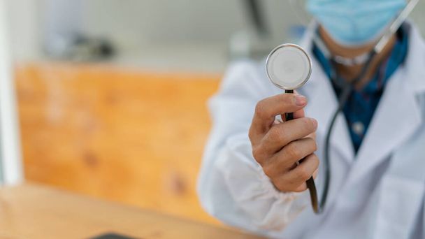 Médico con estetoscopio en la mano, médico profesional en uniforme en la oficina del hospital - Foto, Imagen