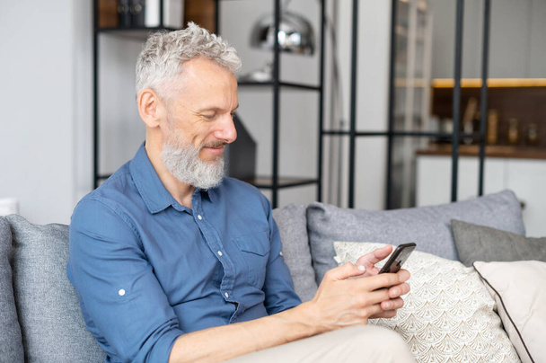 Middle aged bearded man using smartphone - Fotoğraf, Görsel