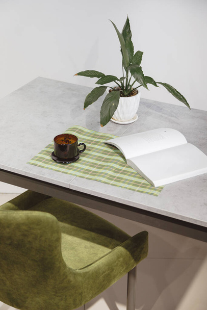 Nowoczesne minimalistyczne miejsce pracy. Zielony welurowy fotel i stół na poddaszu z rośliną domową w białym garnku - Zdjęcie, obraz