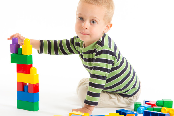 Petit garçon mignon jouant avec les blocs de construction. Isolé sur blanc
. - Photo, image