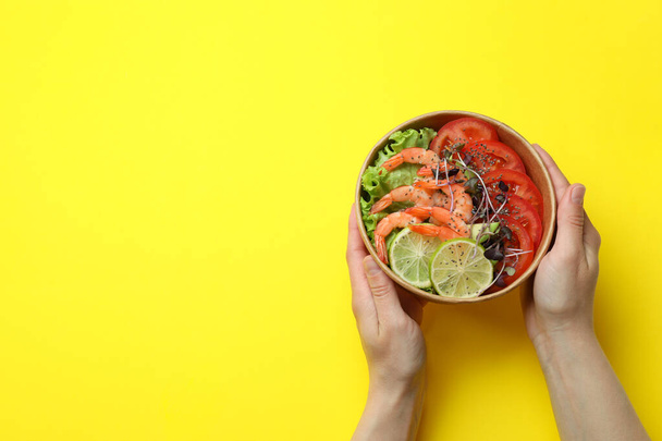 Concept of tasty eating with shrimp salad on yellow background - Photo, Image