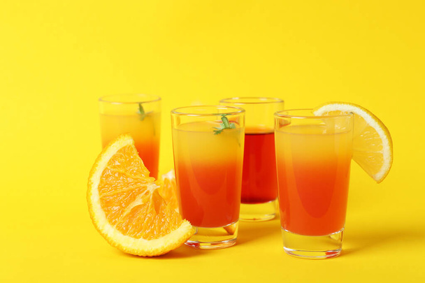Tequila sunrise cocktails and ingredients on yellow background - Φωτογραφία, εικόνα