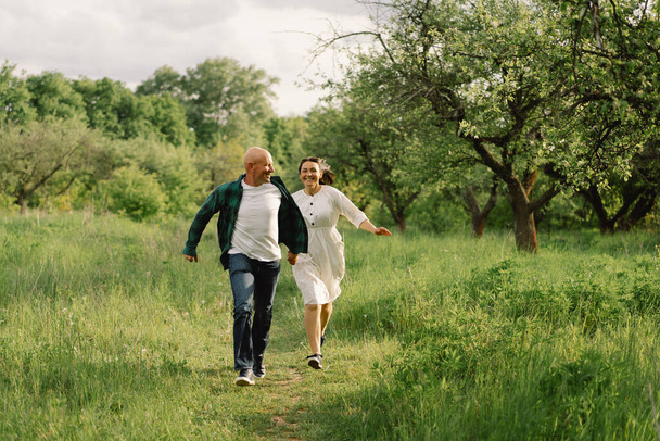 Portrait of an adult couple in love in the spring garden. - Foto, afbeelding