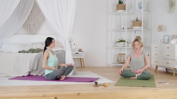 Instructor de yoga mostrando a mujer joven ejercicio respiratorio - Metraje, vídeo