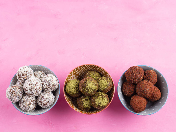 Healthy energy balls with nut butter, dried fruit, oats, seeds. Cocoa, coconut and matcha flavours - Фото, изображение