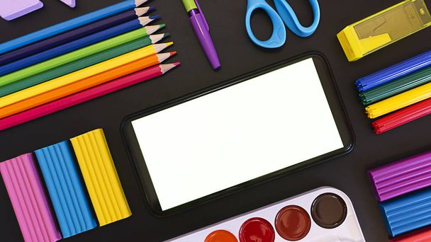 School flatley on the topic back to school, school supplies on a chalk board from above with a copy space on the phone screen - Foto, Imagem