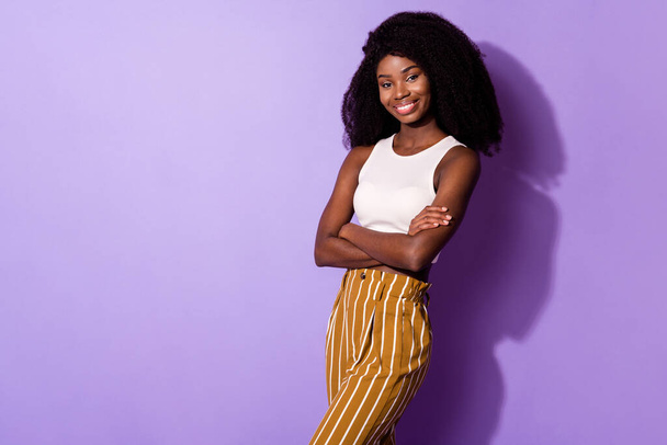 Photo of pretty glad dark skin girl folded arms beaming smile look camera isolated on violet color background - Fotó, kép