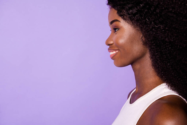 Cropped profile photo of adorable dark skin lady toothy smile look empty space isolated on violet color background - 写真・画像