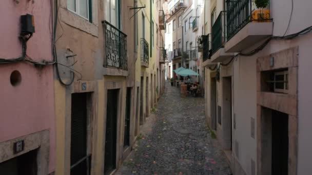 Punto de vista vista vista de la calle de caminar por las calles adoquinadas en Lisboa, Portugal con la gente sentada y charlando en cafés locales - Metraje, vídeo