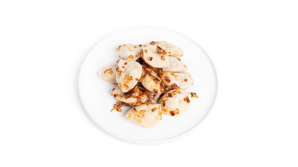 Ζυμαρικά με πατάτες και τηγανητά κρεμμύδια σε λευκό πιάτο που απομονώνονται σε λευκό φόντο. - Φωτογραφία, εικόνα