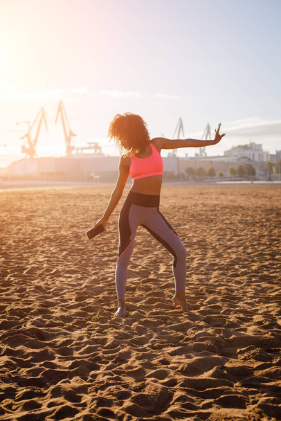 Young sporty fitness black woman on dancing at city beach. Healthy lifestyle and exercising.  Gijon, Asturias, Spain. - Valokuva, kuva