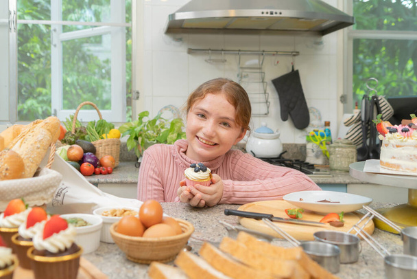 Portré boldog mosolygós nyugati lány tanulás főzni egy torta desszert, Élelmiszer kenyér, pirítós, tészta a konyhában otthon vagy otthon, boldog családi házi pékség. Emberek aktivitás életmód hétvégén - Fotó, kép