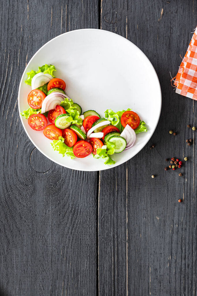 frisches Salatgemüse Tomaten, Gurken, Zwiebeln, Salat Bio-Gericht auf dem Tisch gesunde Nahrung Mahlzeit Snack Kopie Raum Lebensmittel Hintergrund rustikal. von oben Keto oder Paläo Diät veggie vegan oder vegetarisch - Foto, Bild
