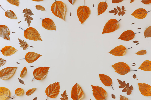 Hermosas hojas naranjas otoñales con espacio en blanco en un centro medio sobre fondo beige. Hola Otoño de concepto de vacaciones de acción de gracias - Foto, Imagen