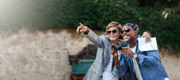 Happy Moments. Cheerful dark skin couple Taking shoot On camera While Having Romantic Date travel, middle age African American Spouses in trip. Woman points the finger Mixed race couple . copy space - Photo, image