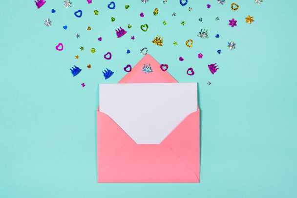 Ροζ φάκελος με party confetti έκρηξη σε μπλε ή τυρκουάζ φόντο. Κάρτα πρόσκλησης, επίπεδη lay. Banner με χώρο αντιγραφής - Φωτογραφία, εικόνα