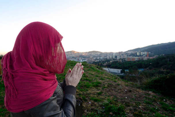 Жінка з червоним шарфом на голові, непізнавана з містом Барселона. - Фото, зображення