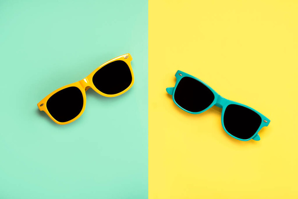 Vue de dessus des lunettes de soleil vertes et jaunes sur fond vert et jaune - Photo, image