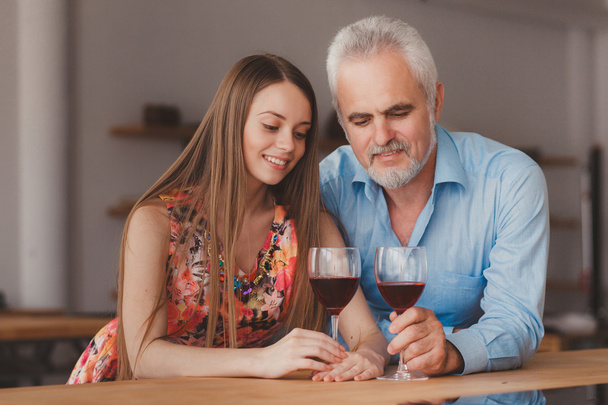 grandfather with his granddaughter drinking wine  in the kitchen - Foto, Bild