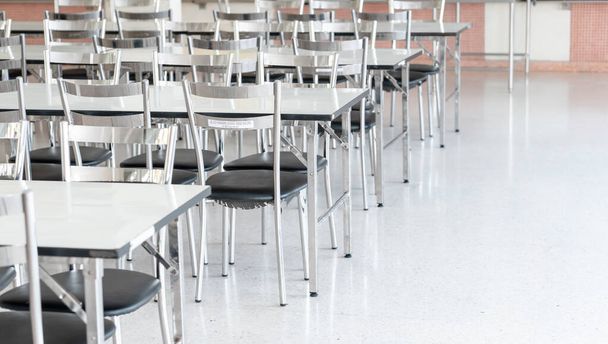 Столи та стільці з нержавіючої сталі у студентській їдальні середньої школи, внутрішній фон кімнати громадської кафетерії
 - Фото, зображення