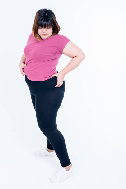 Asijské tlustá žena, která dává pomocí levé ruky na boky, která je velká a plná přebytečného tuku na bílém pozadí, na tlusté ženy a zdravotní péče koncept. - Fotografie, Obrázek