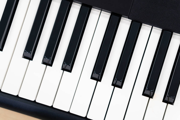 Piano de teclado Midi en mesa de madera, fondo creativo del equipo de entretenimiento del estudio en casa, tecla de sintetizador - Foto, imagen