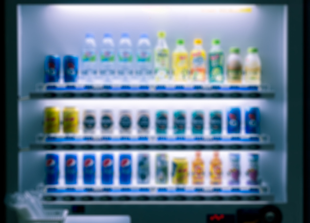 Máquina expendedora borrosa con colorido refresco, café, jugo y fondo de botella de agua, dispensador de bebidas auto moderno fácil y conveniente por la noche - Foto, imagen