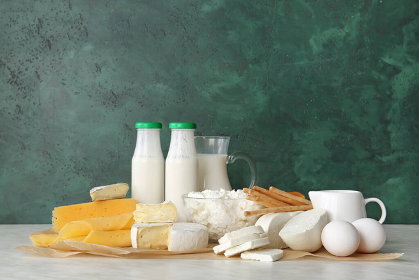 Diferentes productos lácteos y huevos de pollo sobre fondo de color - Foto, Imagen