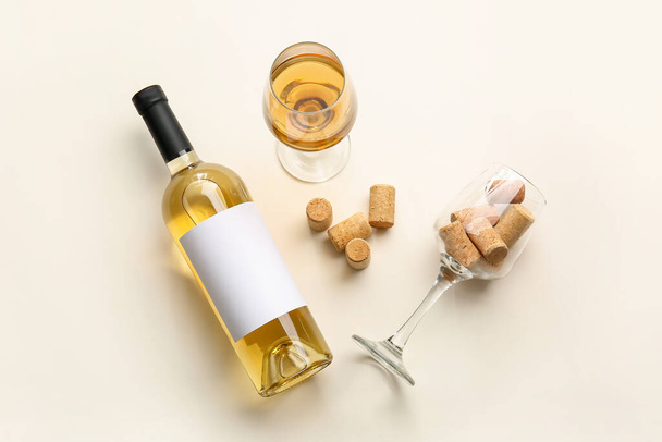 Botella de vino, vasos y corchos sobre fondo claro - Foto, imagen