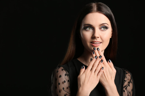 Young woman with beautiful manicure on dark background - Valokuva, kuva