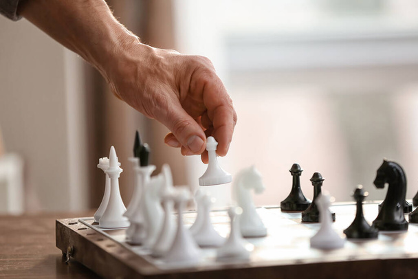 Мужчина играет в шахматы дома - Фото, изображение