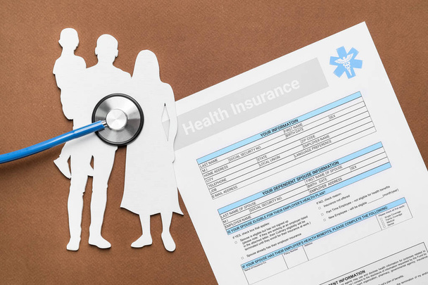 Figuras familiares con formulario de seguro de salud y estetoscopio sobre fondo de color - Foto, Imagen