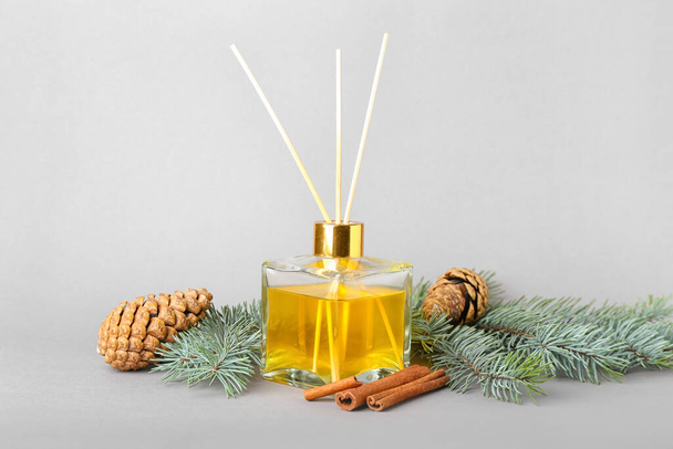 Coniferous reed diffuser with cinnamon on grey background - Photo, Image