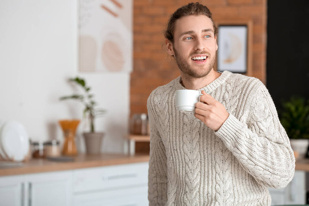 Handsome young man drinking coffee at home - 写真・画像