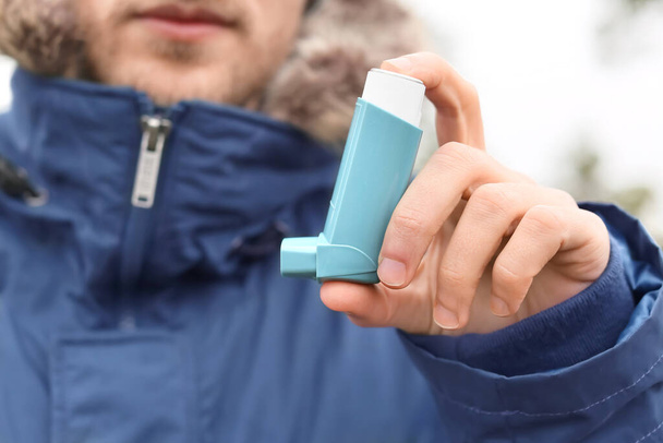 Young man with inhaler outdoors, closeup - 写真・画像
