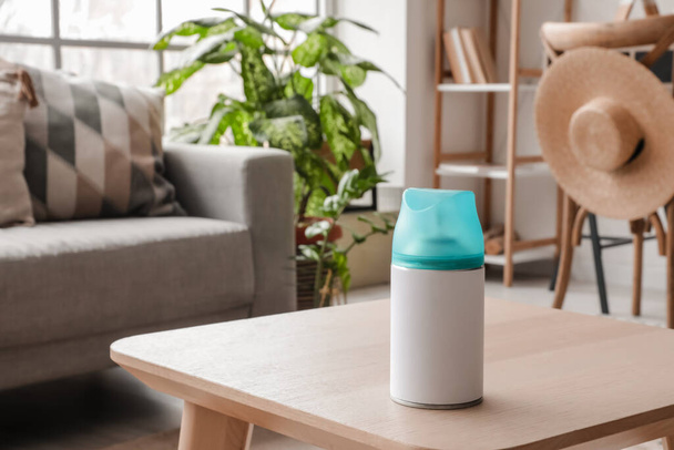 Eine Flasche Lufterfrischer auf dem Tisch im Wohnzimmer - Foto, Bild