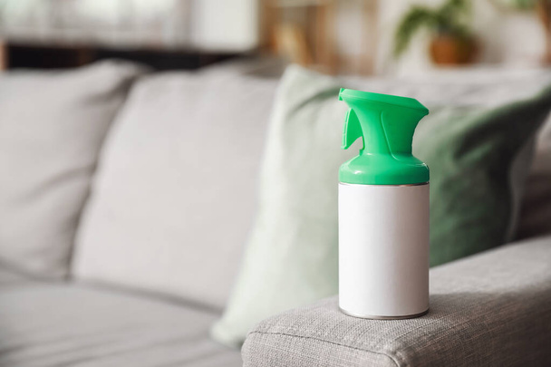 Bottle of air freshener on sofa in room, closeup - Valokuva, kuva