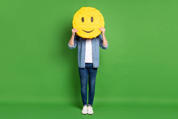 Full length body size photo of man keeping smile icon hiding face isolated bright green color background - Foto, Imagem
